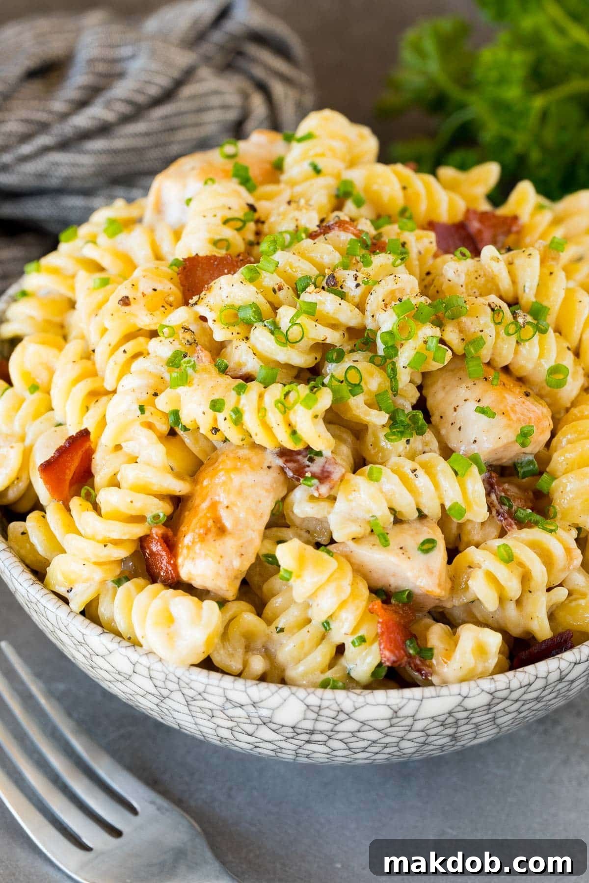 A beautiful bowl of chicken bacon ranch pasta garnished with fresh chives, ready to be enjoyed.