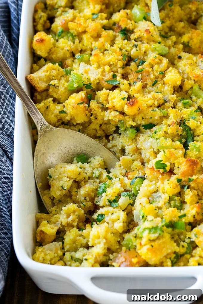 Grandma's Southern Cornbread Dressing 3 Cornbread dressing made with cornbread, white bread and vegetables, with a serving spoon in it.