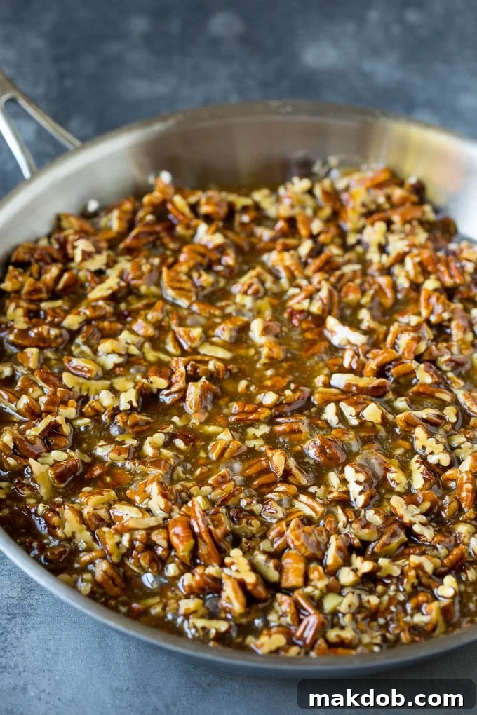 Gooey pecan pie filling simmering in a saucepan, ready to be poured over the crust.