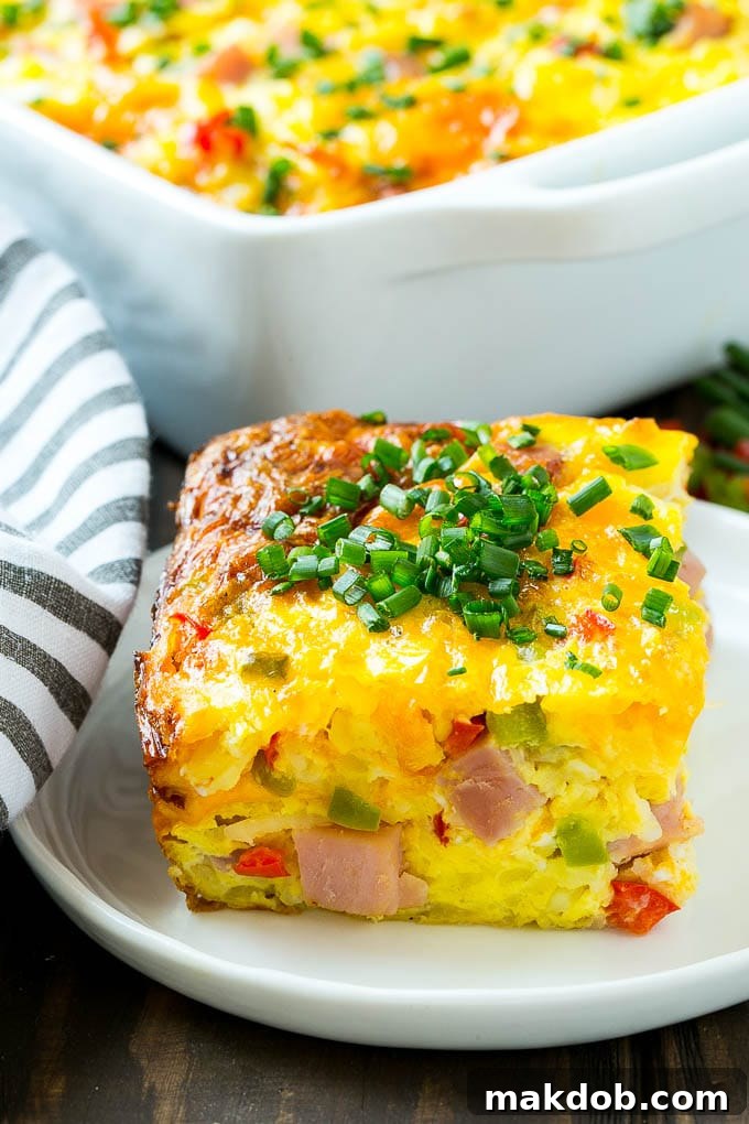 Perfect Slice of Hash Brown Casserole | Layers of Ham, Eggs, and Cheese Breakfast Bake A perfectly cut slice of hash brown casserole showing layers of ham, eggs, vegetables, and cheese.