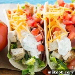 Flavorful chicken ranch tacos featuring grilled chicken, crispy bacon, creamy homemade ranch sauce, cheese, and fresh vegetables, all tucked into warm flour tortillas.