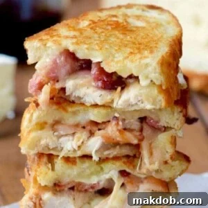 A picture of three turkey, bacon and brie sandwiches stacked.