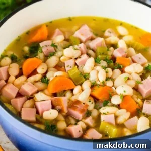A rustic pot of Ham and Beans, beautifully garnished with fresh parsley, ready to be served.