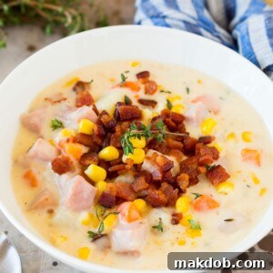 A comforting bowl of Ham and Corn Chowder, richly garnished with crispy bacon bits.