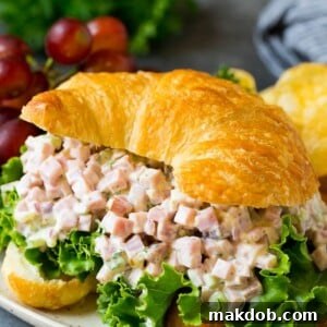 A serving of creamy Ham Salad presented elegantly in a croissant, ready to be enjoyed.