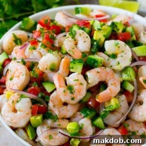 A bowl of shrimp ceviche marinated in citrus juice with tomato, avocado, cilantro and jalapeno.