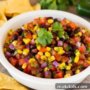 A bowl of black bean and corn salsa with tortilla chips.