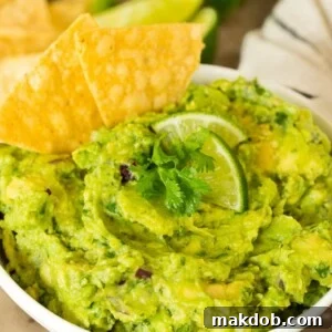 A bowl of Chipotle guacamole with chips.