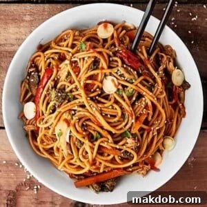 An image of slow cooker lo mein in a white bowl with black chopsticks.