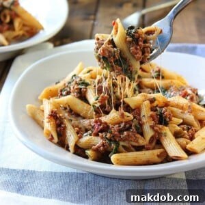 A savory image of slow cooker beef and cheese pasta, with melted cheese and rich meat sauce glistening under the light.
