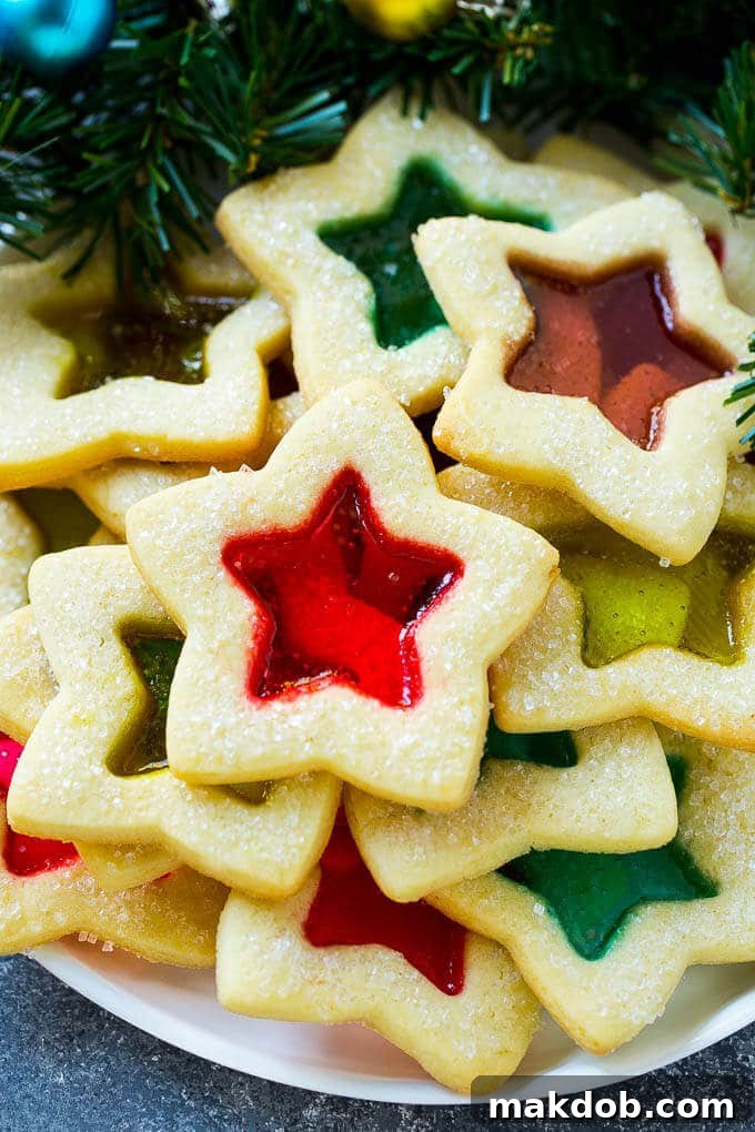 Stained glass cookies filled with melted candy and sprinkled with sugar. A beautiful, colorful holiday dessert.