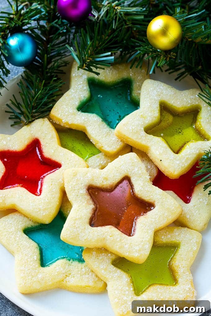 A plate of star shaped stained glass cookies with colorful centers, ready to be served.