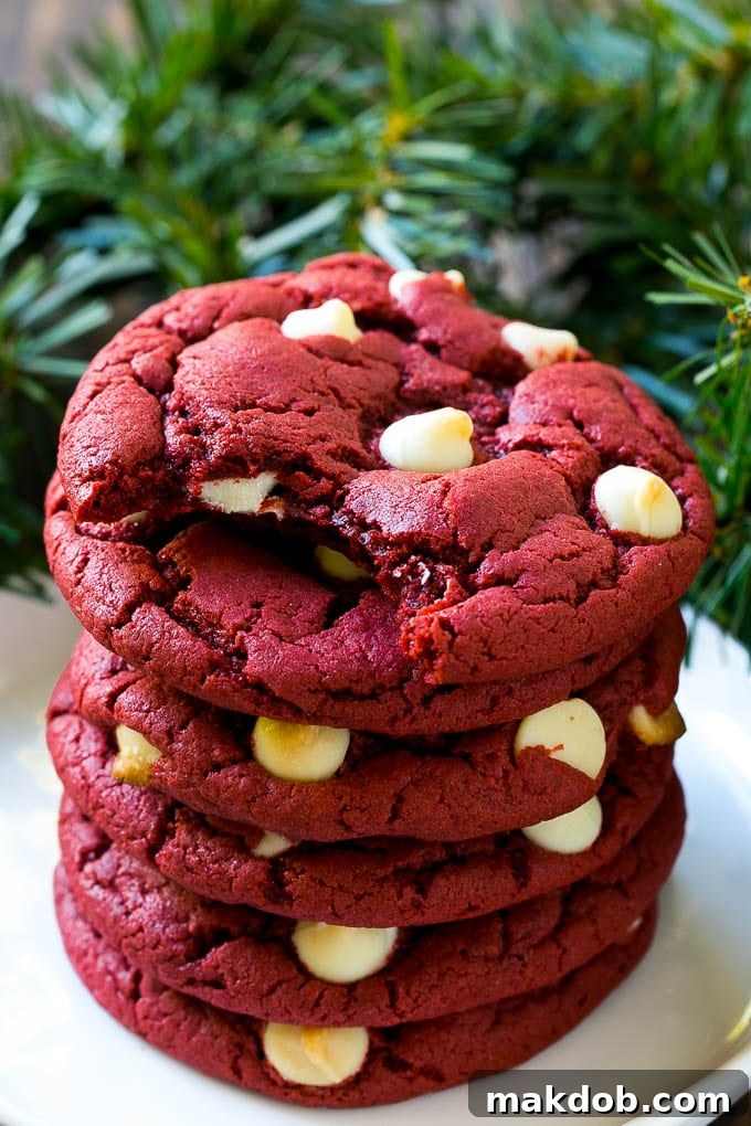 Red Velvet Cookies Recipe | Red Velvet Cookies with White Chocolate Chips | Red Velvet Cake Mix Cookies #redvelvet #cookies #whitechocolate #christmas #dinneratthezoo A stack of red velvet cookies on a plate, ready to be served.