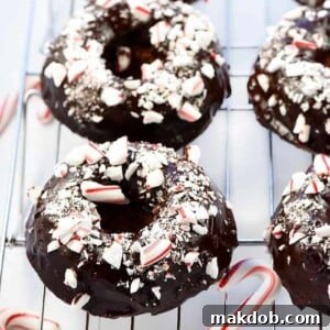 An inviting image of chocolate peppermint baked donuts cooling on a wire rack.