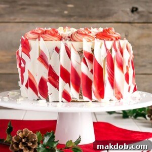A grand White Chocolate Candy Cane Cake, beautifully decorated and presented on a platter, ready to be the centerpiece of any holiday celebration.