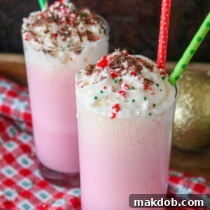 A picture of two inviting candy cane milkshakes generously topped with whipped cream.