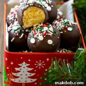 Irresistible cake truffles nestled in a festive tin, with one piece showing a tantalizing bite taken out.