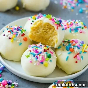 Delectable cake balls presented on a plate, with one piece showcasing a delightful bite taken out, revealing its moist interior.