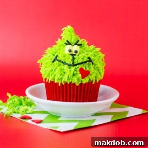 A picture of a grinch cupcake on a red background.