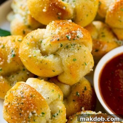These easy garlic knots are smothered in butter, garlic, herbs and parmesan and are baked to golden brown perfection. A quick side dish for any meal!