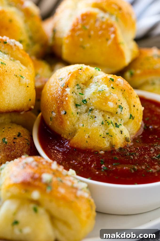 Garlic Knot Dipped in Sauce A garlic roll being dipped into marinara sauce for a delicious finishing touch.