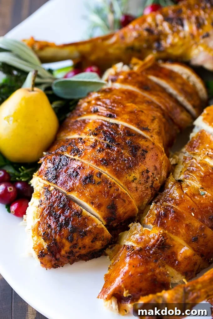 Perfectly sliced herb roasted turkey arranged on a serving platter, garnished with fresh herbs, ready to be enjoyed as the ideal holiday main course.