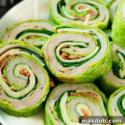 These turkey roll ups are pinwheel sandwiches filled with cheese, avocado, bacon, turkey and spinach.