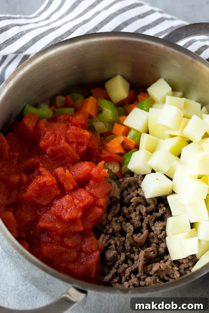 Loaded Burger Soup 5 Potatoes and diced tomatoes are added to the soup pot before simmering, enhancing the richness and texture of the hamburger soup.