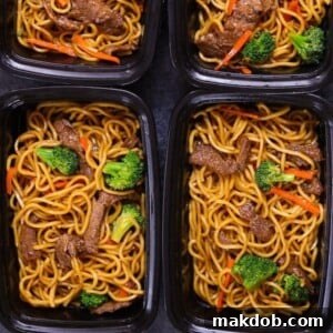 Several black containers filled with delicious beef lo mein, perfectly portioned for meal prep.