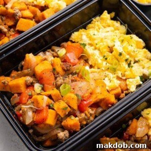 An image of a delicious and satisfying breakfast meal prep featuring eggs, sweet potato, and sausage hash.