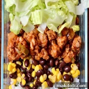 An inviting image of a well-balanced taco bowl featuring seasoned turkey, fluffy rice, crisp lettuce, and hearty beans.