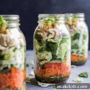 A beautifully layered Asian chicken salad in a mason jar, perfect for a fresh work lunch.