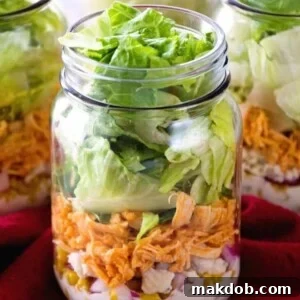 An image of a delicious Buffalo chicken salad perfectly layered in a mason jar.