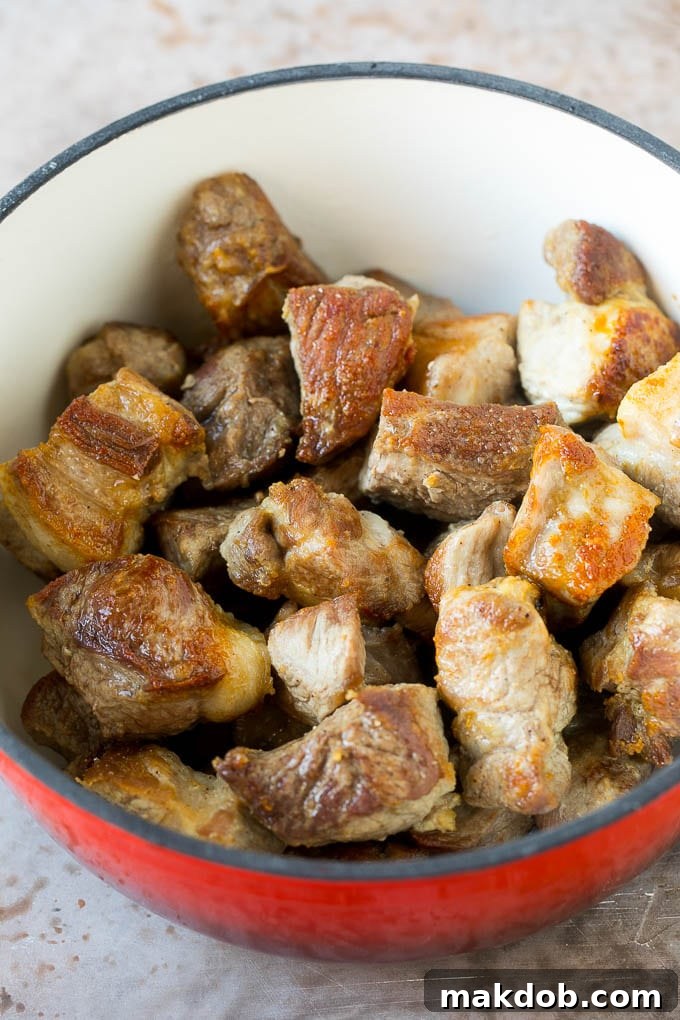 Seared pork shoulder pieces in a pot.