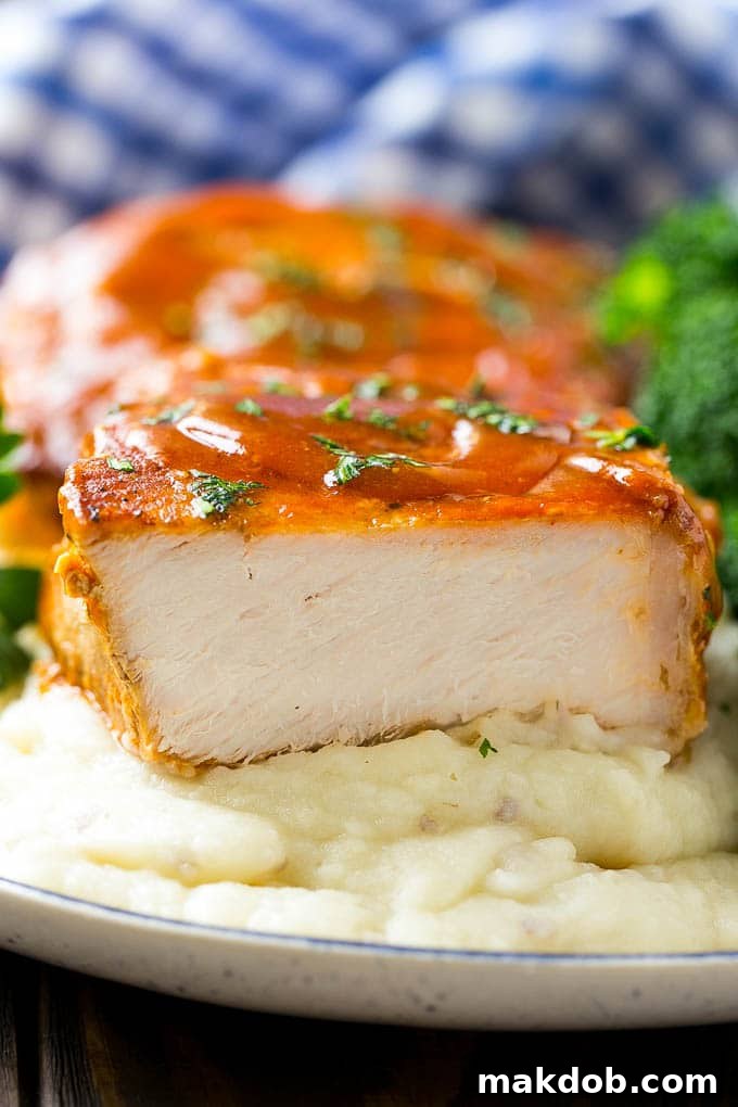 A cross section of a honey garlic pork chop served on mashed potatoes.