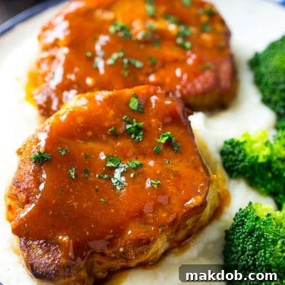 Honey garlic pork chops served over mashed potatoes with a side of broccoli.