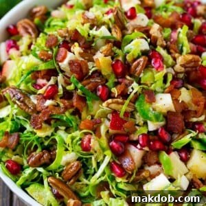Brussels sprout salad with shredded brussels sprouts, pomegranate, pecans, feta cheese, apples and bacon.