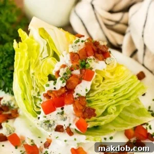 A wedge salad topped with bacon, tomatoes and cheese.