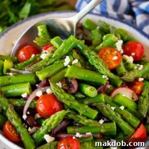 Asparagus salad with a serving spoon in it.