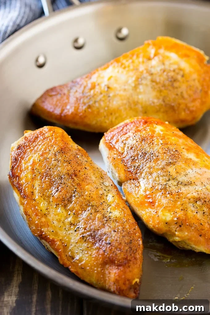 Perfectly seared, golden-brown chicken breasts resting in a frying pan before the sauce is made.