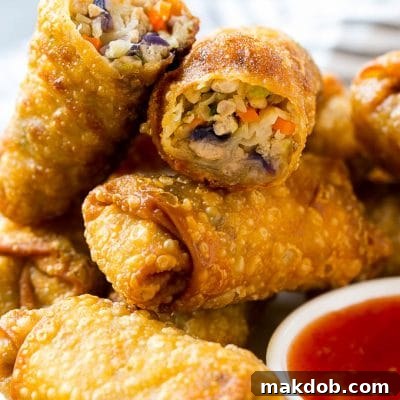 A plate of homemade egg rolls with dipping sauce.