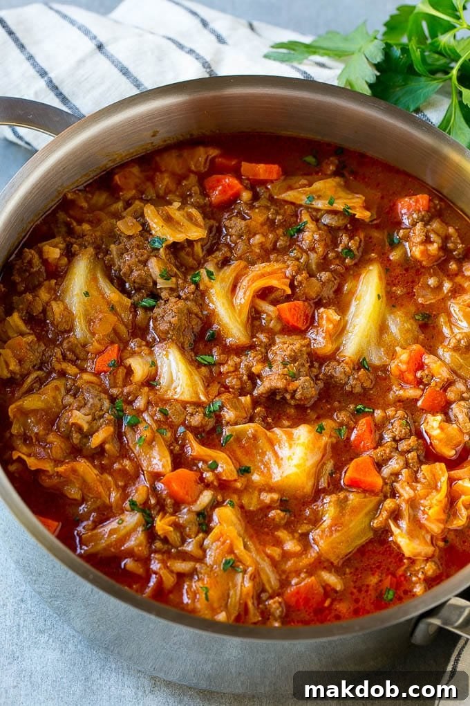 A pot full of cabbage roll soup garnished with parsley.