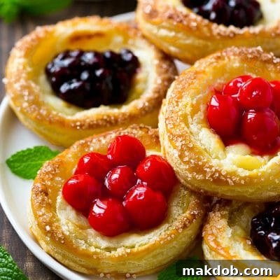 A platter of cream cheese danish topped with fruit.