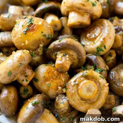 Garlic mushrooms in an herb and butter sauce in a frying pan.