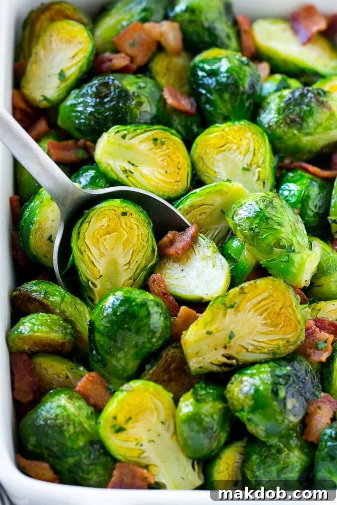 Served: Delicious Bacon Roasted Brussels Sprouts A beautiful serving dish filled with perfectly roasted Brussels sprouts, crispy bacon, and fresh parsley.