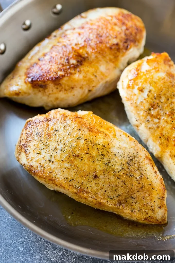 Seared chicken breasts achieving a beautiful golden-brown color in a hot pan, ready for the next step in the baked lemon chicken recipe.
