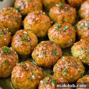 Chicken meatballs in a skillet of garlic butter.