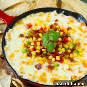 Hot corn dip made with two types of cheese, corn, peppers and bacon, served with tortilla chips.