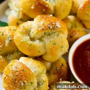 These easy garlic knots are smothered in butter, garlic, herbs and parmesan and are baked to golden brown perfection. A quick side dish for any meal!