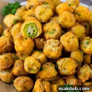A serving plate of fried okra garnished with parsley.